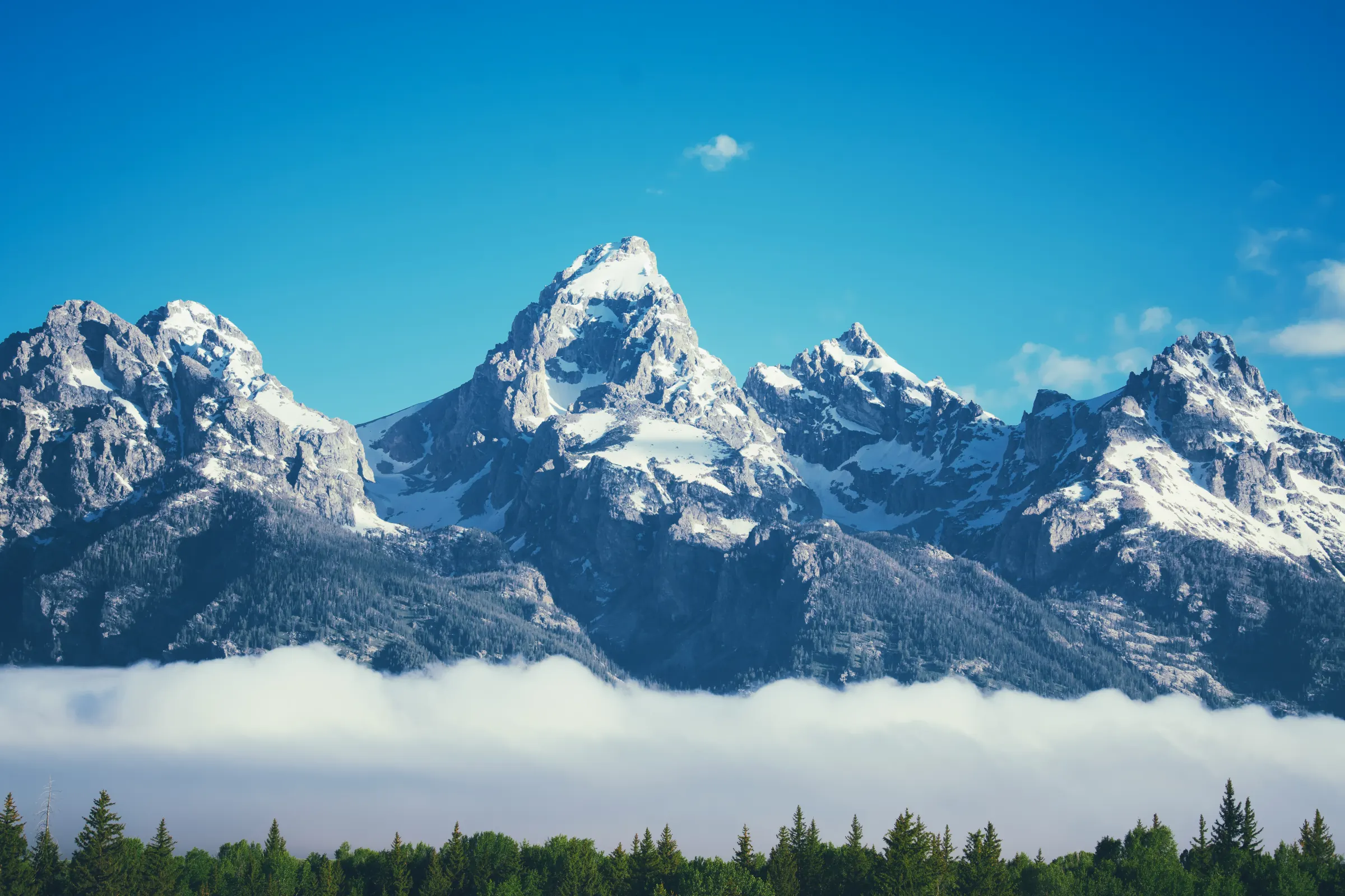 Snow-covered mountain peaks beneath a clear blue sky